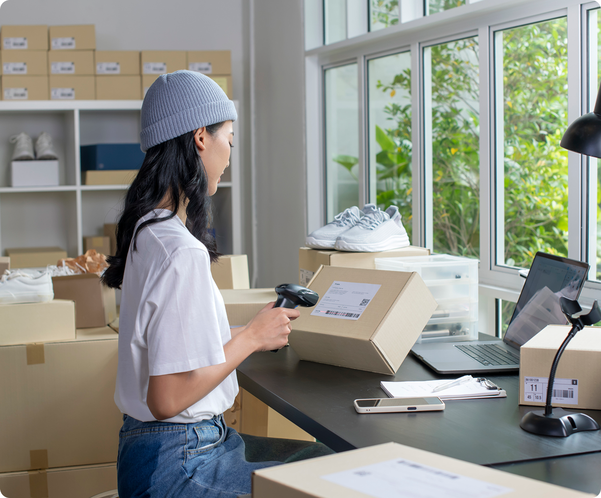 Woman scanning package in home office